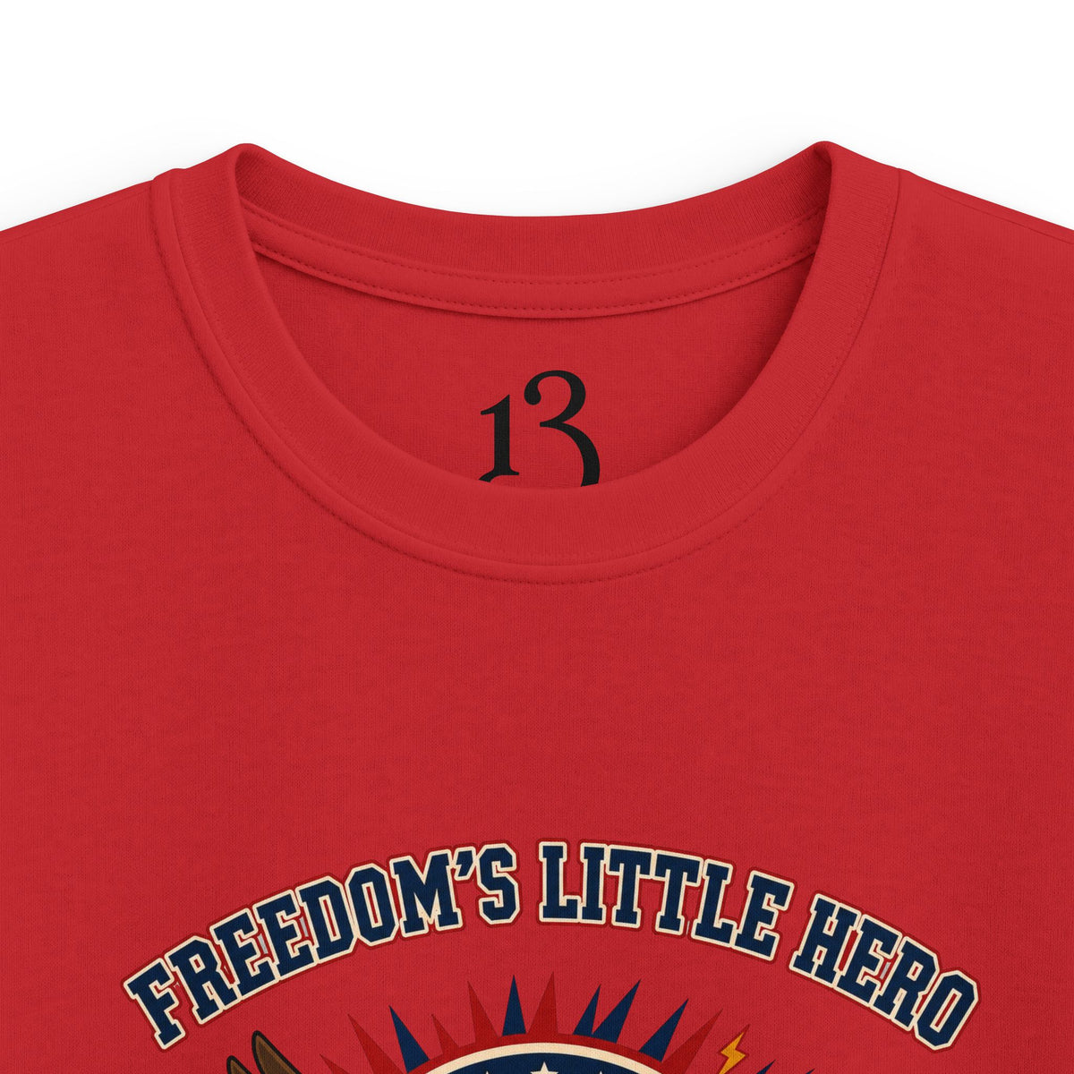 Close-up of red kids T-shirt neckline and “Freedom’s Little Hero” graphic.