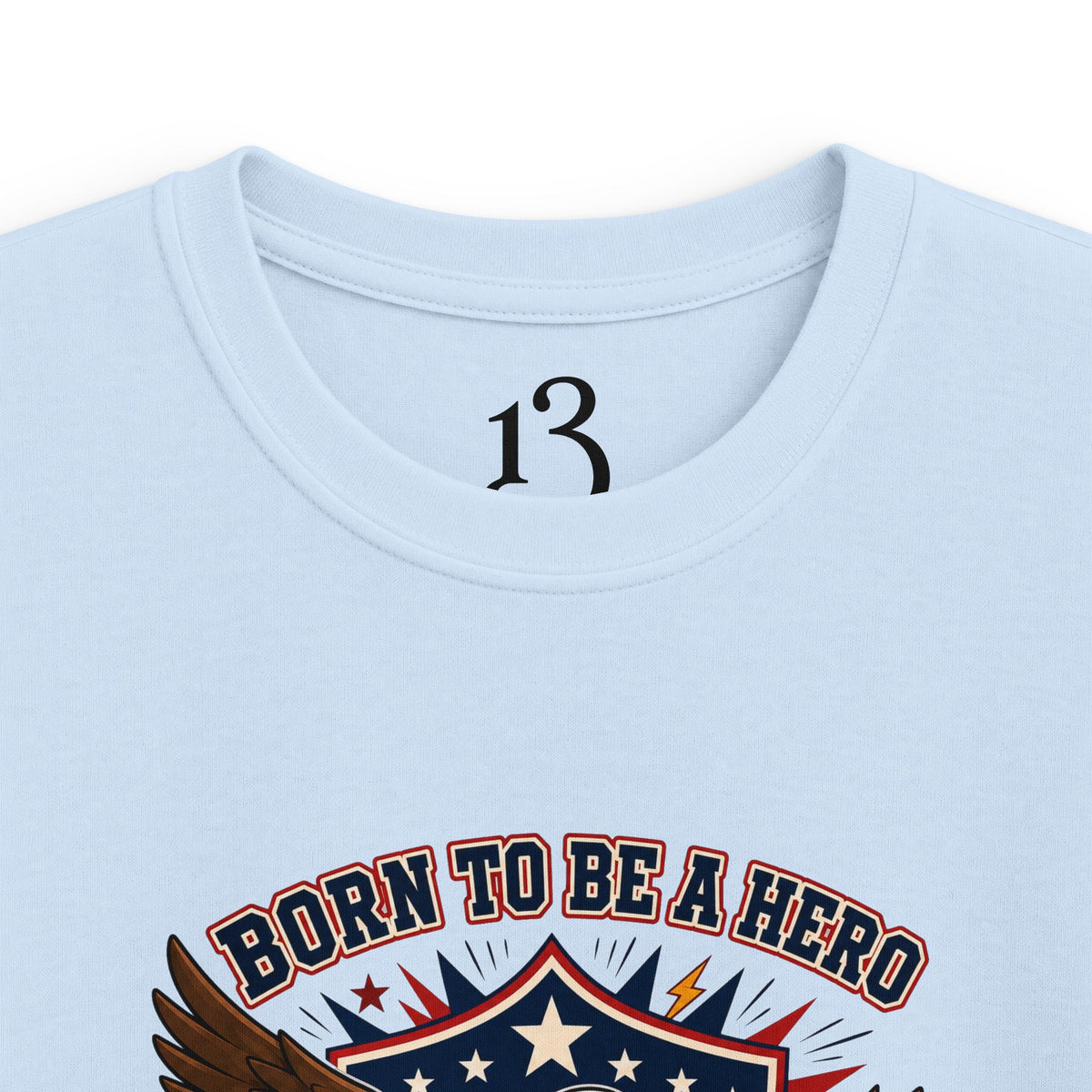 Close-up of light blue kids T-shirt neckline and “Born to Be a Hero” graphic.