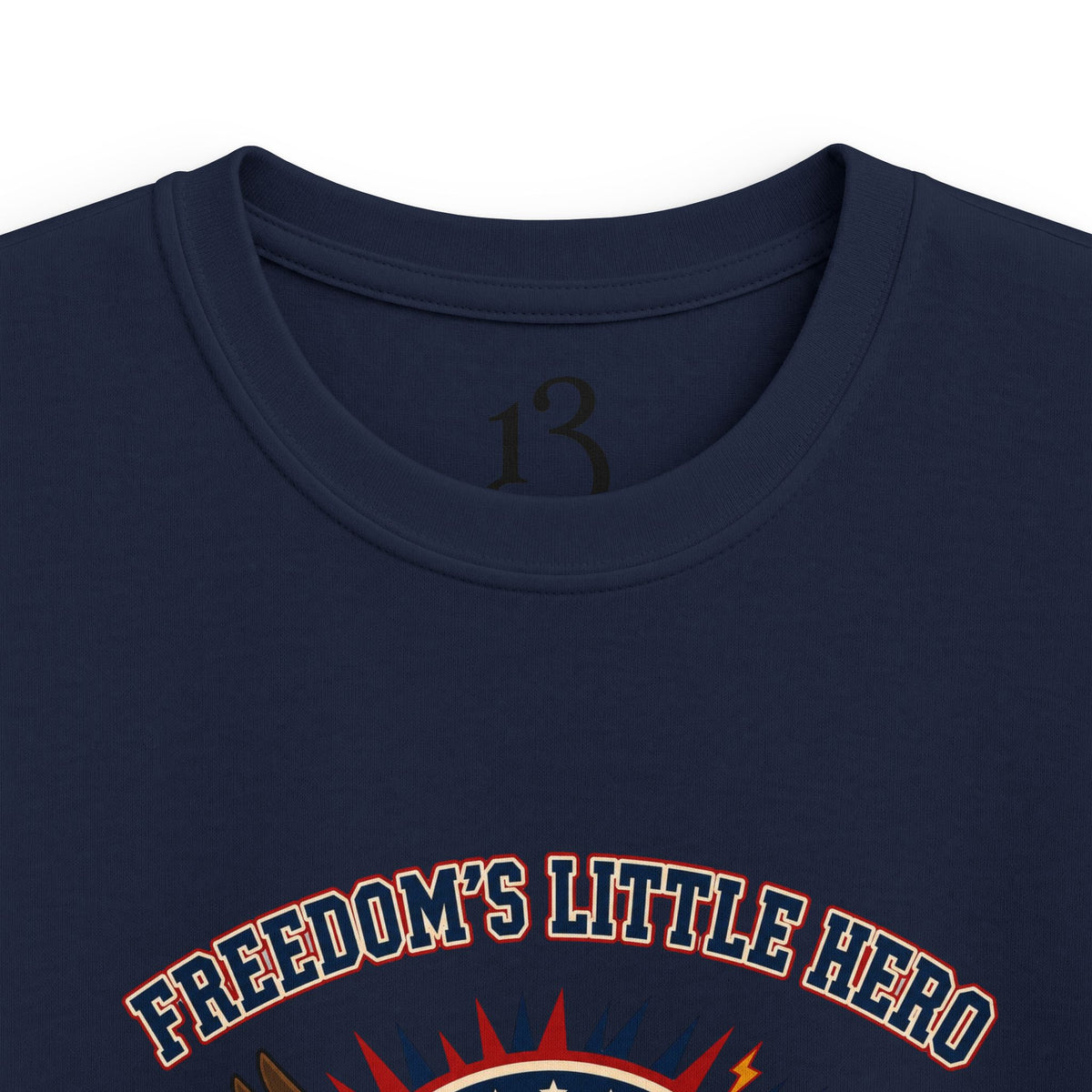 Close-up of navy kids T-shirt neckline and “Freedom’s Little Hero” graphic.