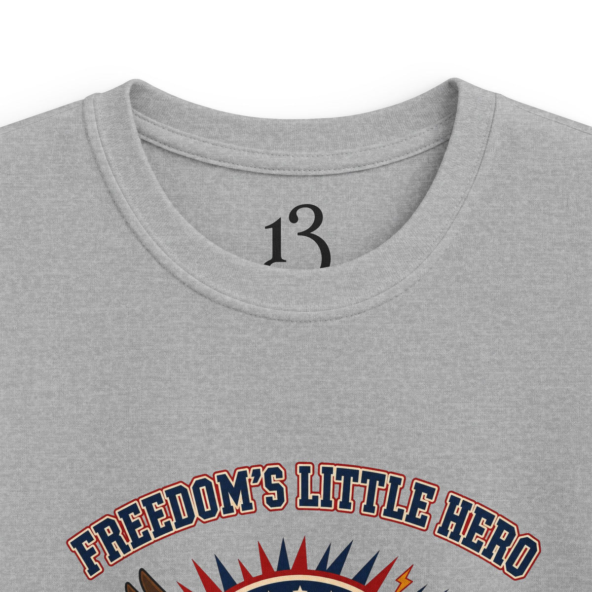 Close-up of sport grey kids T-shirt neckline and “Freedom’s Little Hero” graphic.