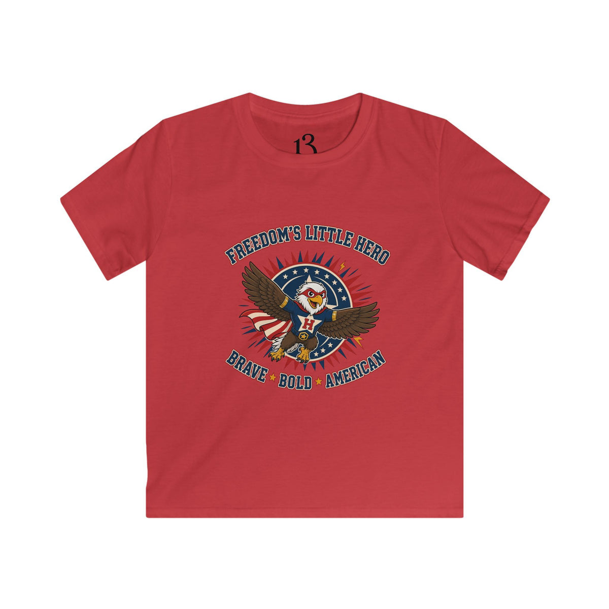 Front view of red kids T-shirt with a superhero eagle and “Freedom’s Little Hero — Brave, Bold, American” lettering.