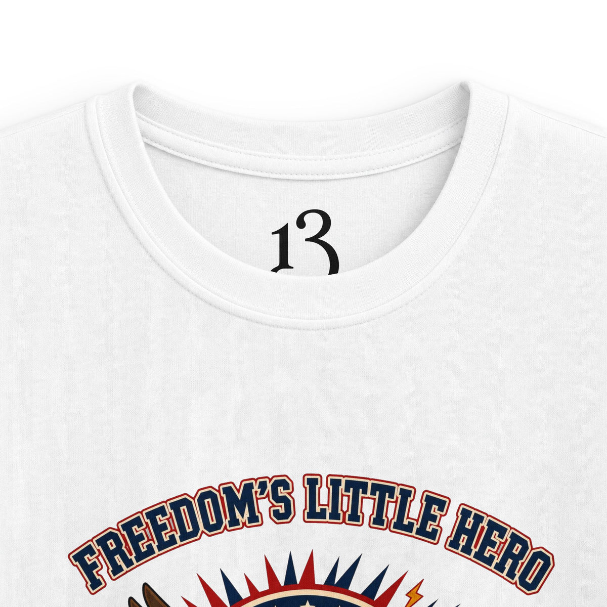 Close-up of white kids T-shirt neckline and “Freedom’s Little Hero” graphic.