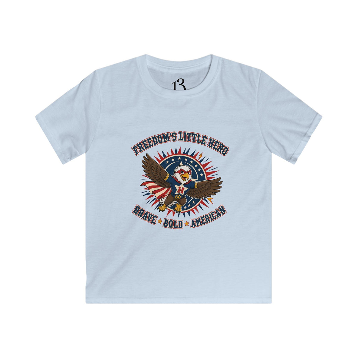 Front view of light blue kids T-shirt with a superhero eagle and “Freedom’s Little Hero — Brave, Bold, American” lettering.
