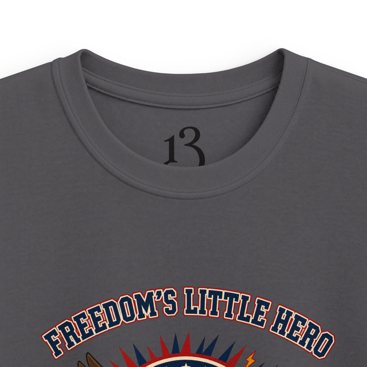 Close-up of charcoal kids T-shirt neckline and “Freedom’s Little Hero” graphic.