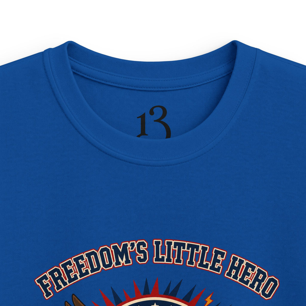 Close-up of royal blue kids T-shirt neckline and “Freedom’s Little Hero” graphic.
