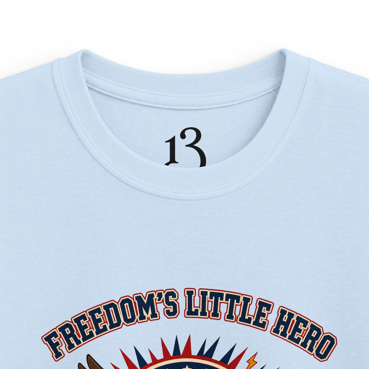 Close-up of light blue kids T-shirt neckline and “Freedom’s Little Hero” graphic.