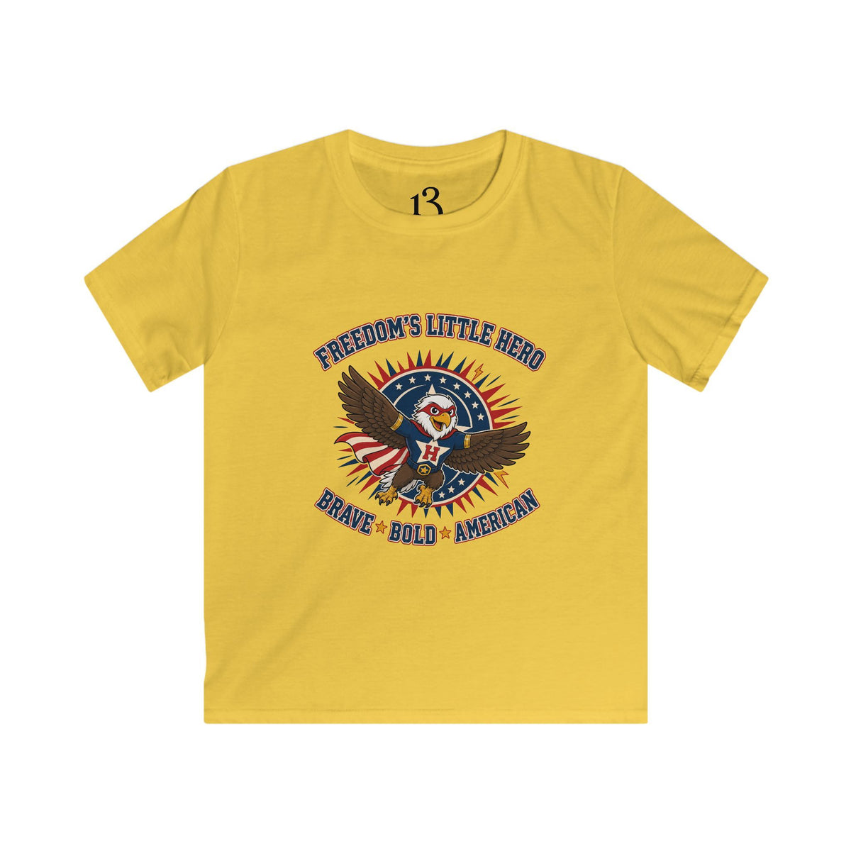 Front view of yellow kids T-shirt with a superhero eagle and “Freedom’s Little Hero — Brave, Bold, American” lettering.