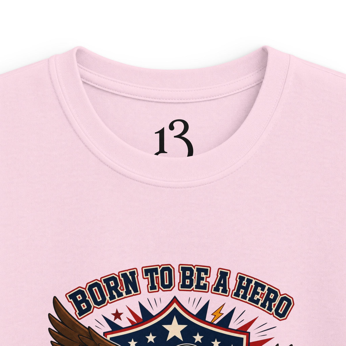 Close-up of light pink kids T-shirt neckline and “Born to Be a Hero” graphic.